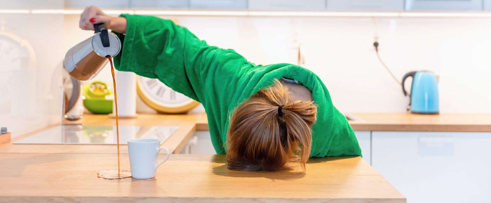 フランスで、緑のパーカーを着た女性がキッチンカウンターの上に立っています。