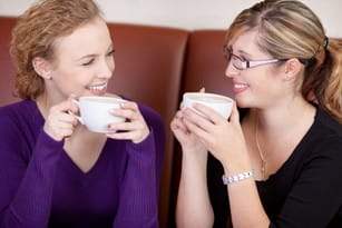 フランス風のコーヒー ショップでコーヒーを飲む 2 人の女性。