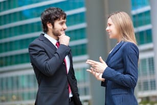 フランスの建物の前で話している 2 人のビジネスマン。