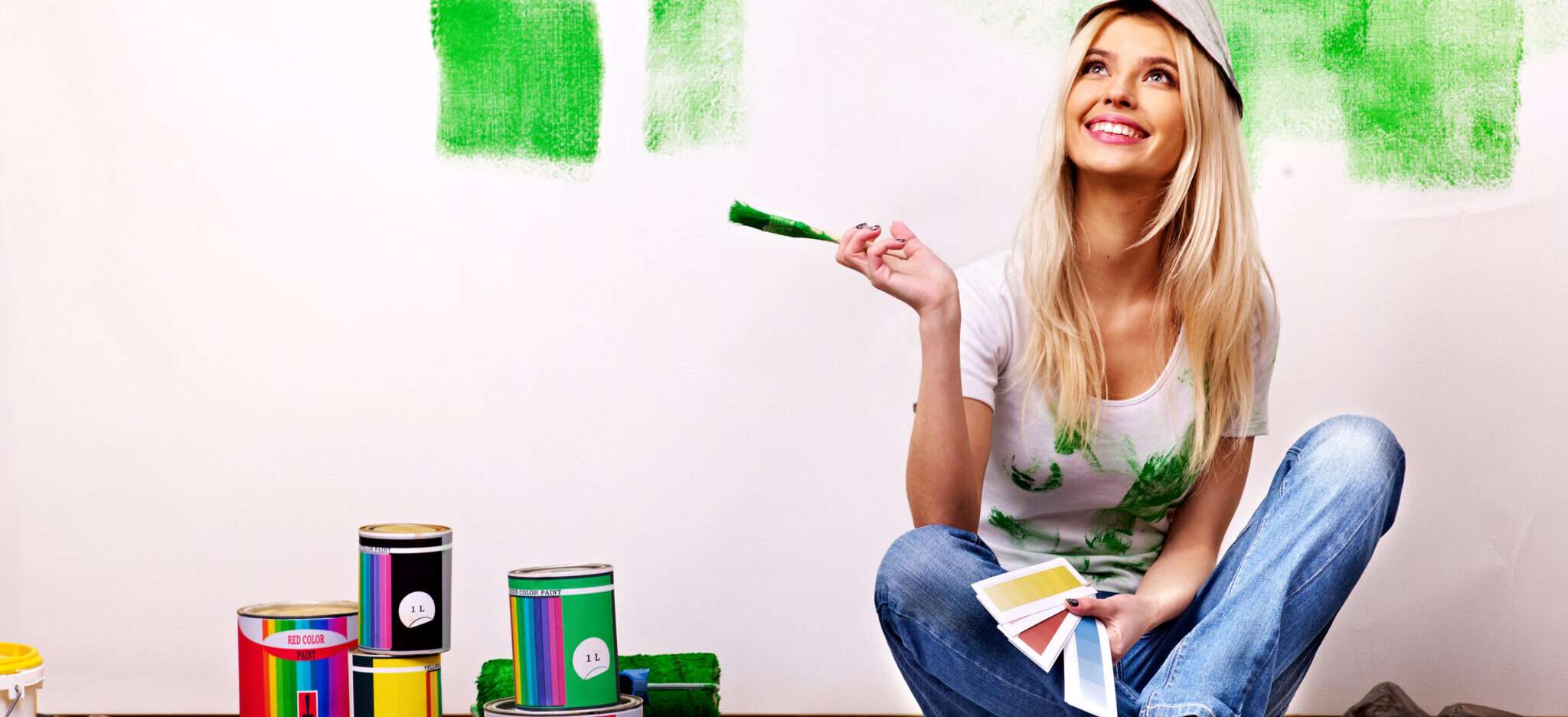 緑色のペンキで壁を塗るフランスの女性。