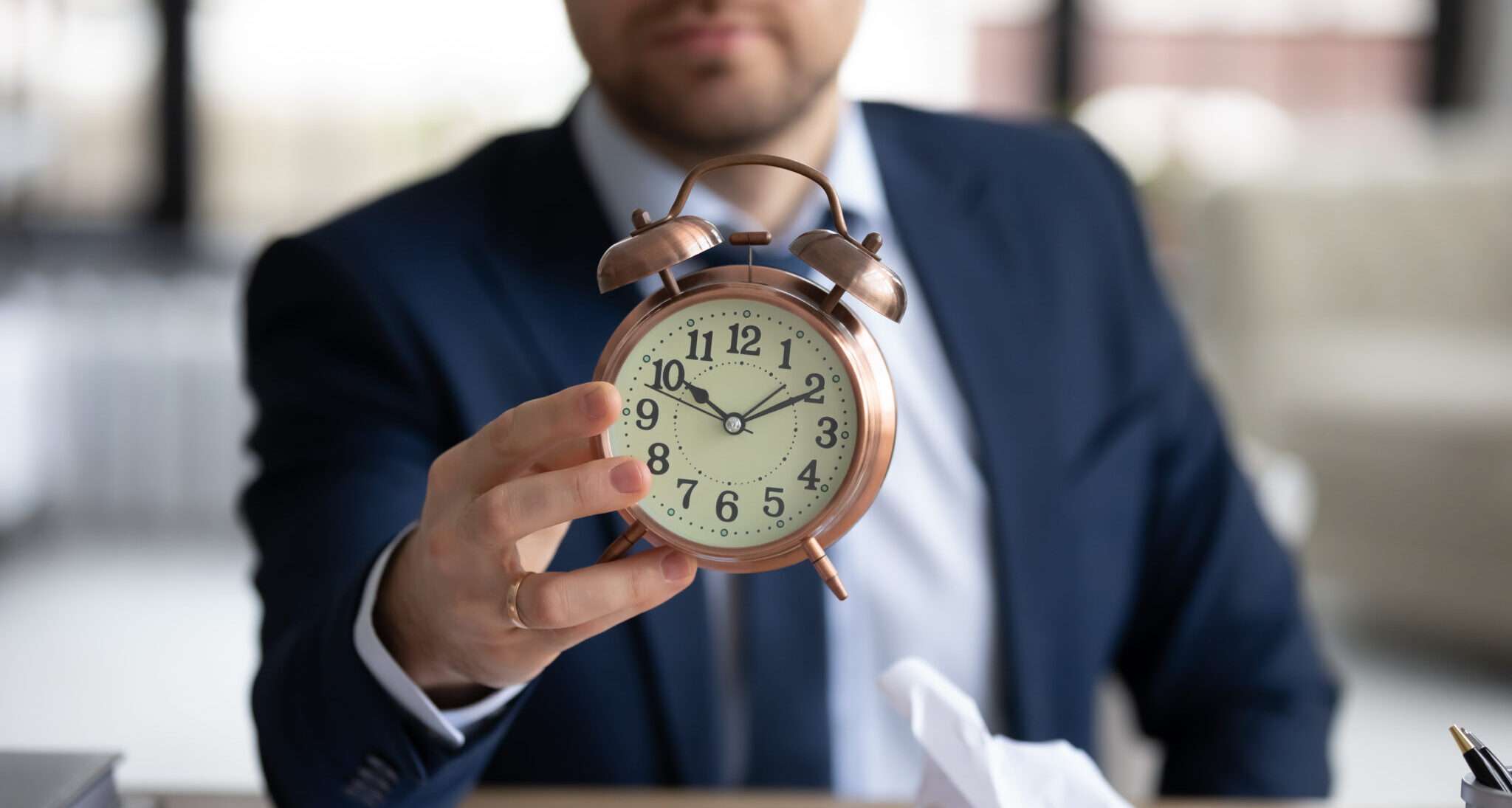 フランスで目覚まし時計を持ったスーツを着た男性。