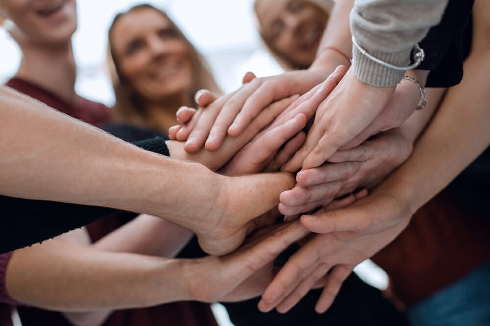 輪になって手を合わせるフランス人のグループ。