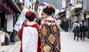 京都の通りを歩く二人の芸者。