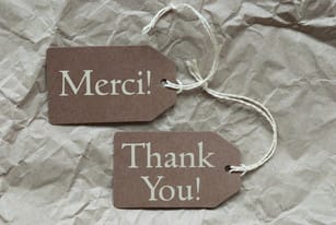 フランスからの「merci thank you」の文字が入った茶色のタグが 2 つあります。