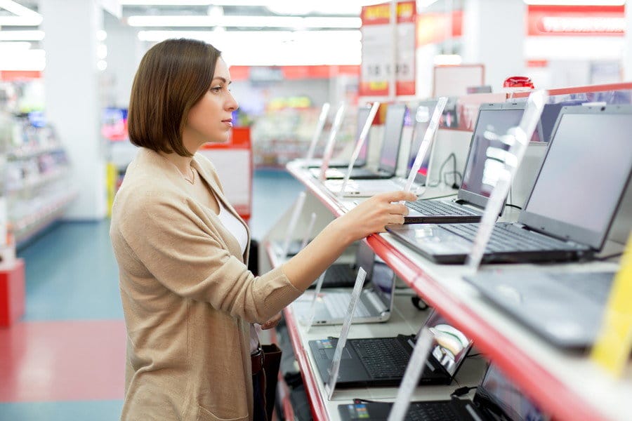フランスの店舗でラップトップを見ている女性。