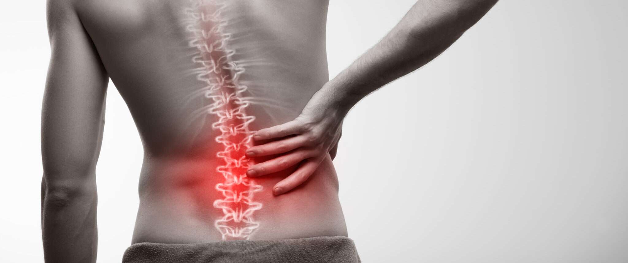 腰痛を抱えるフランスから来た男性が腰を支えている。