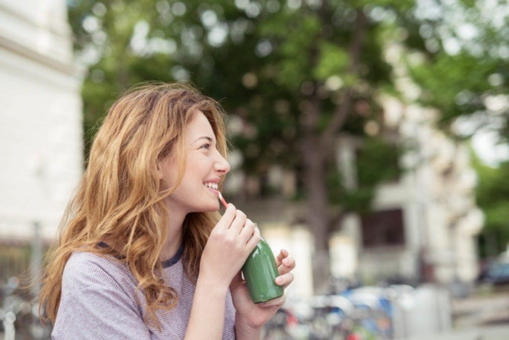 フランスのパリ市でグリーンスムージーを飲む若い女性。