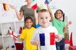 教室でフランス国旗を掲げる子供たちのグループ。