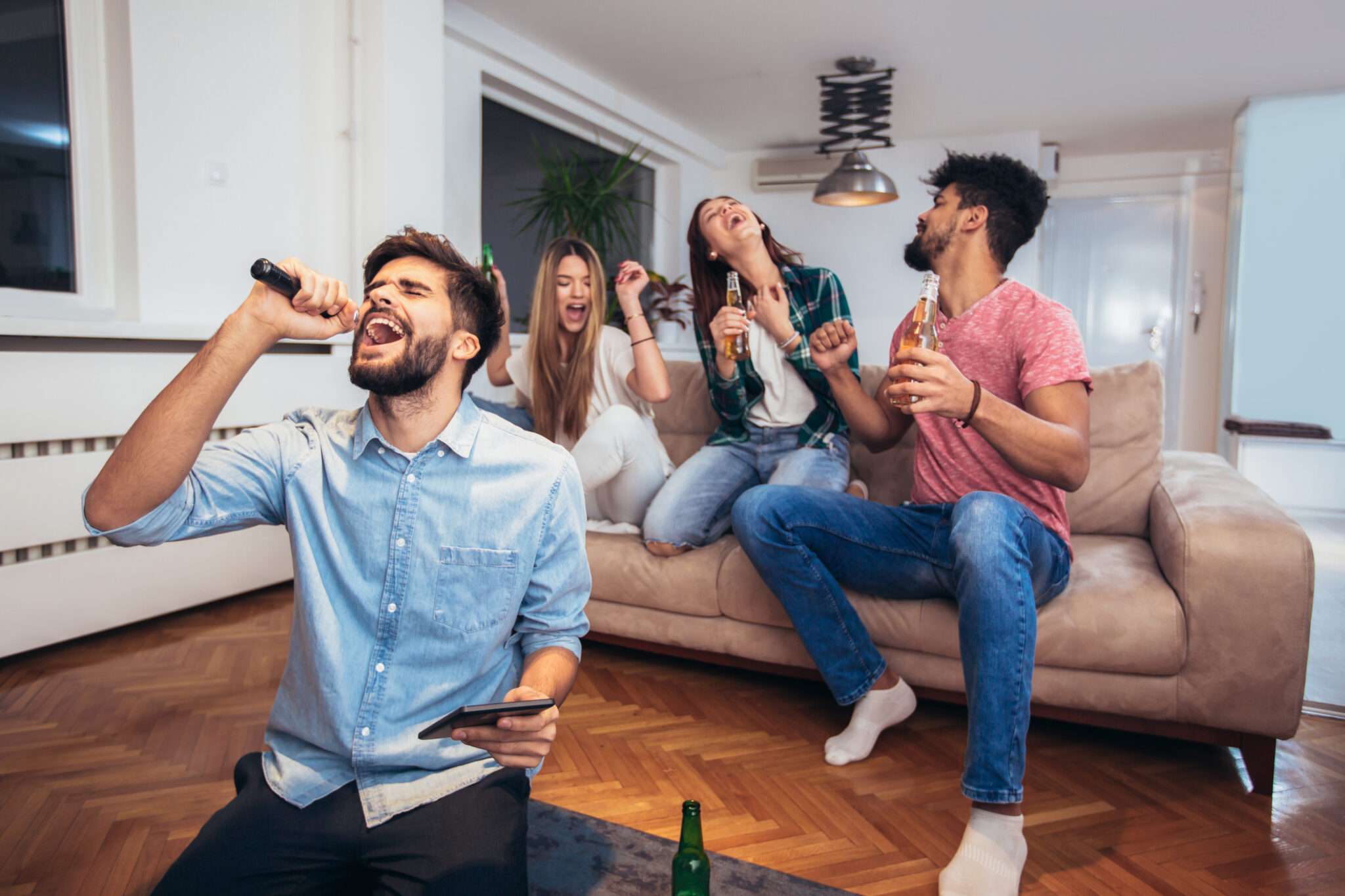 フランスのリビングルームで歌いながら酒を飲む人々のグループ。 フランスのリビングルームで歌いながら酒を飲む人々のグループ。