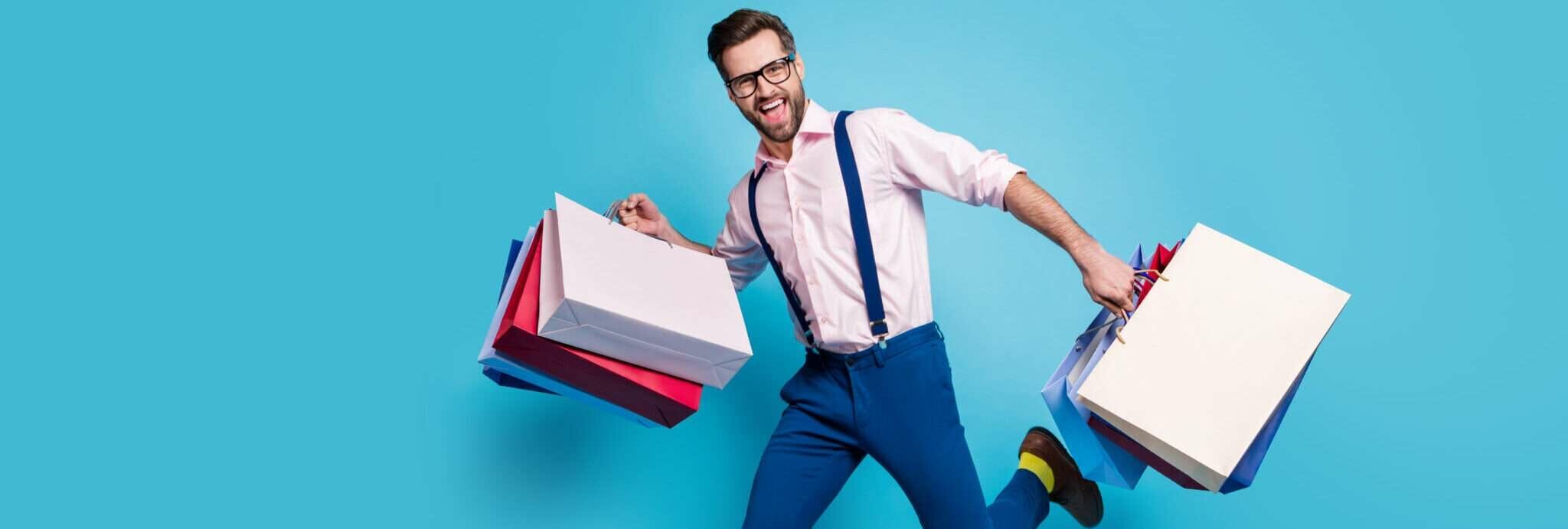 フランスで青い背景に買い物袋を持って走る男性。