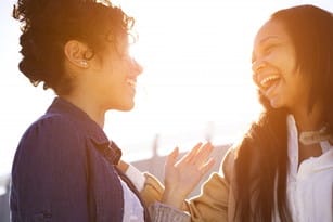 フランスの太陽の前で笑う二人の女性。