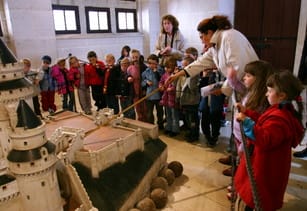 フランスの城の模型を見ている子供たちのグループ。