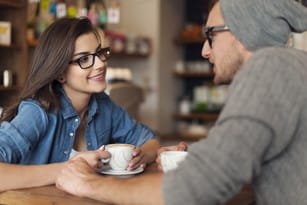 フランスの豊かな文化遺産にインスピレーションを得た男性と女性がテーブルに座り、おいしいコーヒーを楽しんでいます。