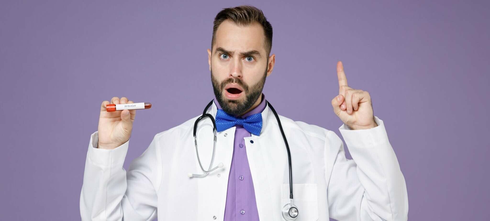 注射器を持って指を指すフランスの医師。