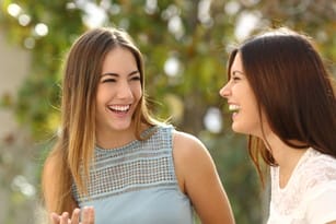 フランスの 2 人の女性が笑いながら話しています。