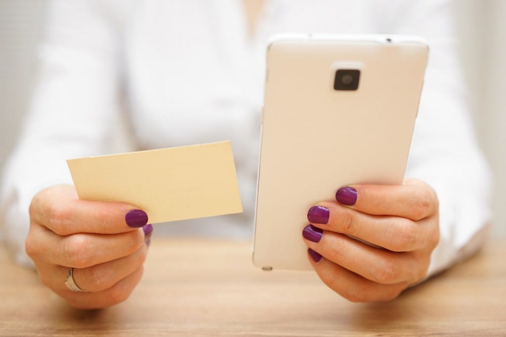 フランスで名刺と携帯電話を持つ女性。