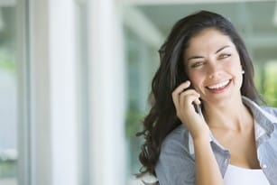 フランスで携帯電話で話す笑顔の女性。