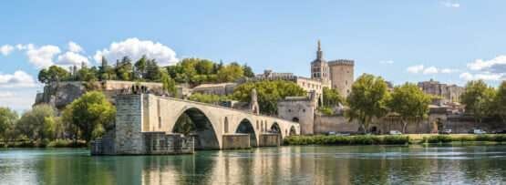 フランスにある、背景に城がある川にかかる橋。