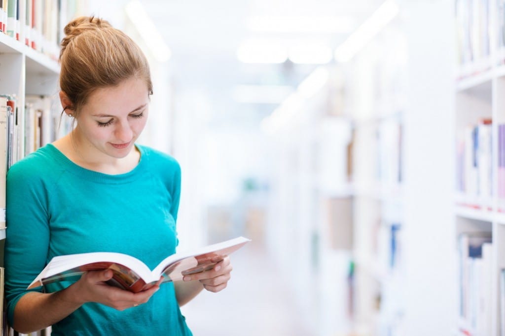 図書館でフランスに関する本を読んでいる若い女性。