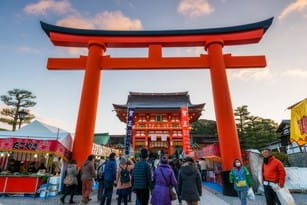 フランスのオレンジ色の鳥居の前に立つ人々のグループ。