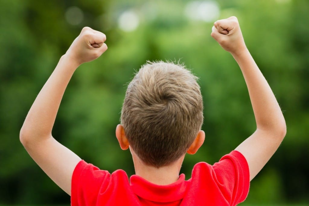 フランスで拳を空に突き上げる少年。