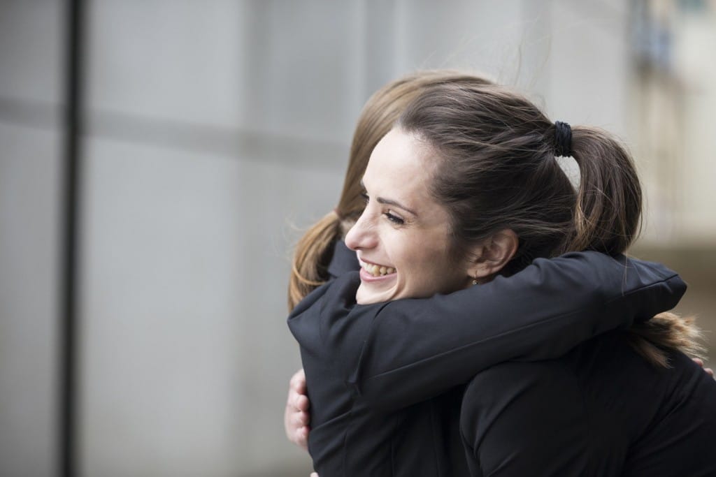 フランスの建物の外で抱き合う2人の女性。