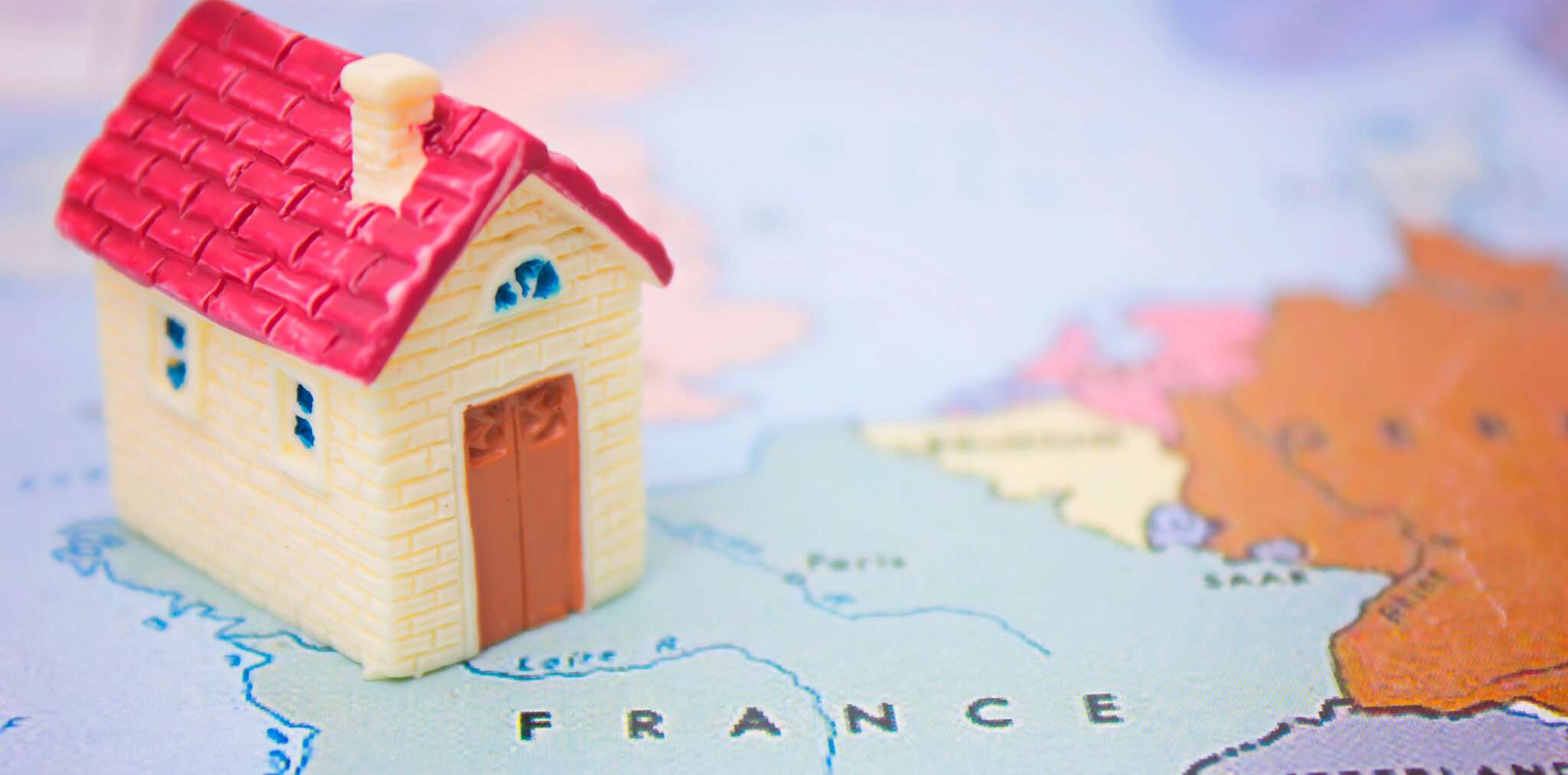 フランスの地図の上にあるおもちゃの家。