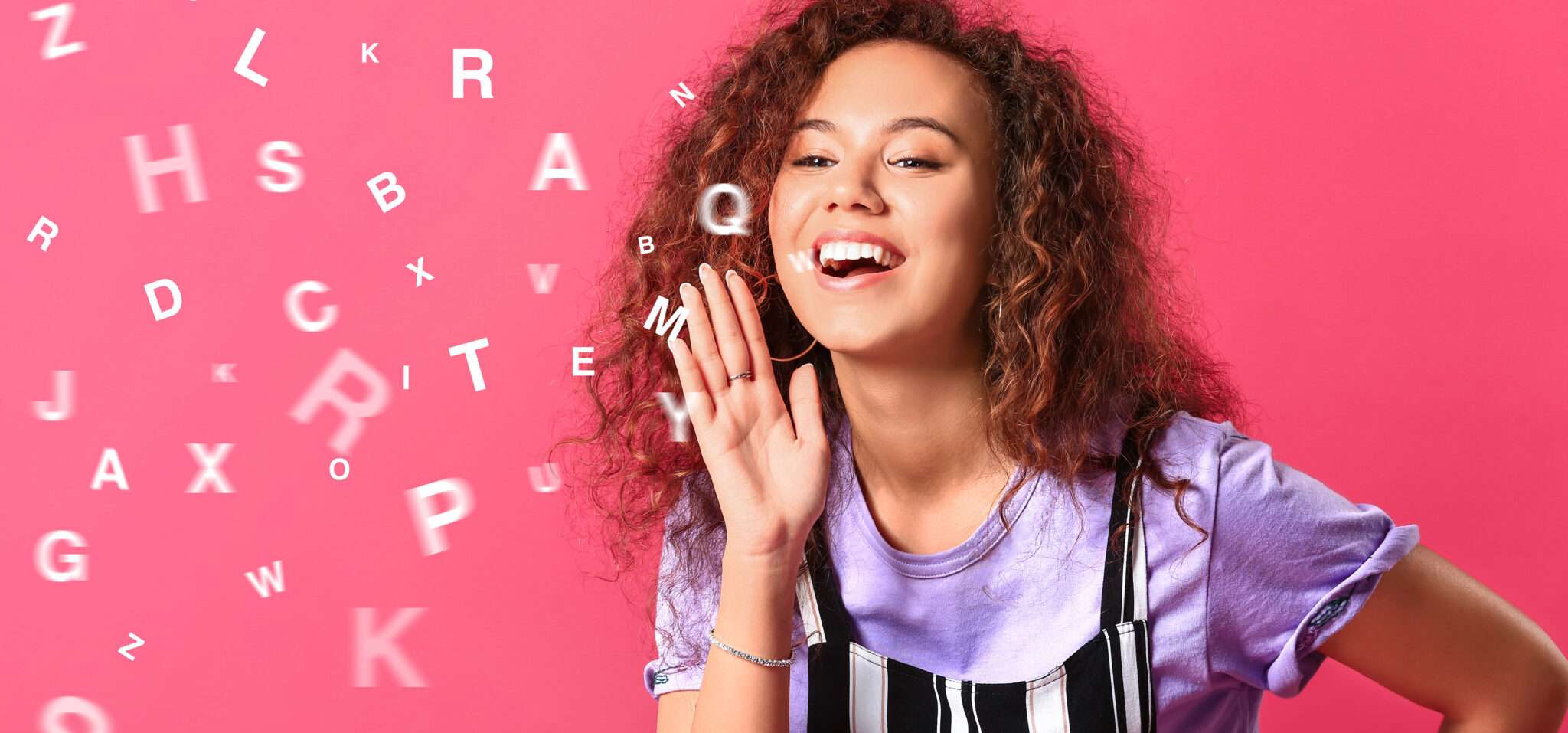 フランスのピンクの背景に文字を吹き飛ばす巻き毛の女性。 フランスのピンクの背景に文字を吹き飛ばす巻き毛の女性。