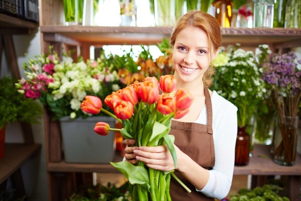 フランスでチューリップの花束を持ったエプロン姿の女性。