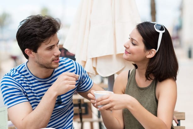 フランスの屋外カフェで話す男性と女性。