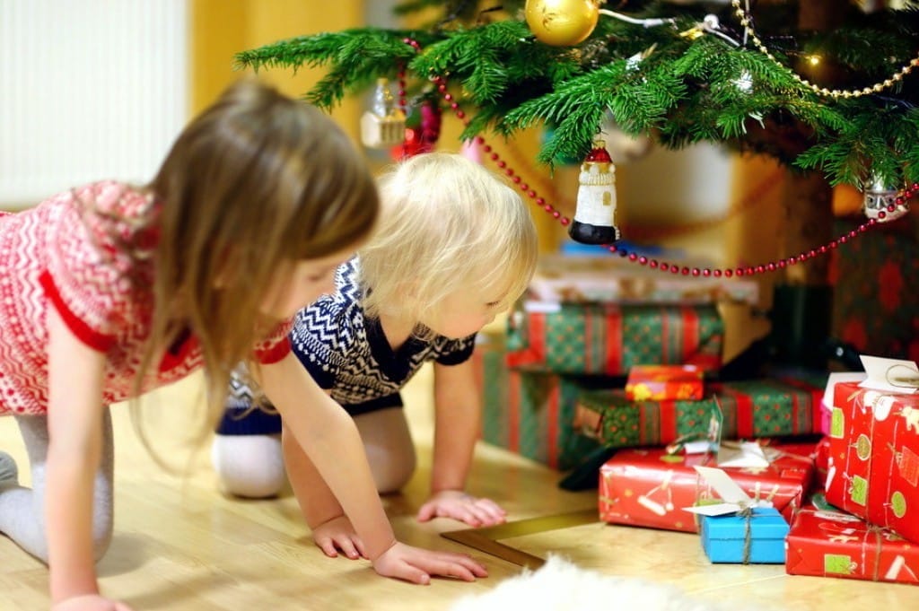 フランスのクリスマスツリーの下でプレゼントで遊ぶ二人の子供。