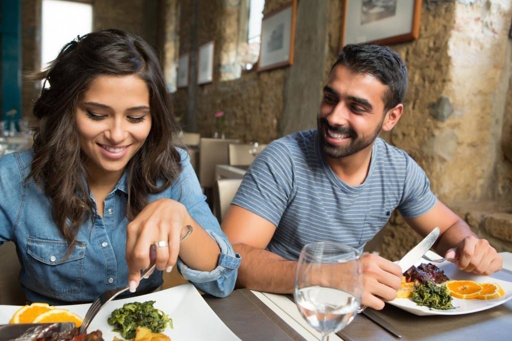 テーブルに座ってフランス料理を食べる男性と女性。