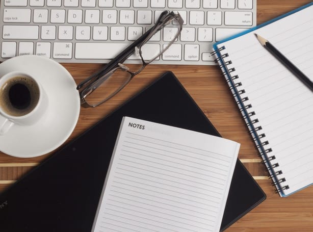 フランスのラップトップ、メモ帳、コーヒーを備えたデスク。 フランスのラップトップ、メモ帳、コーヒーを備えたデスク。