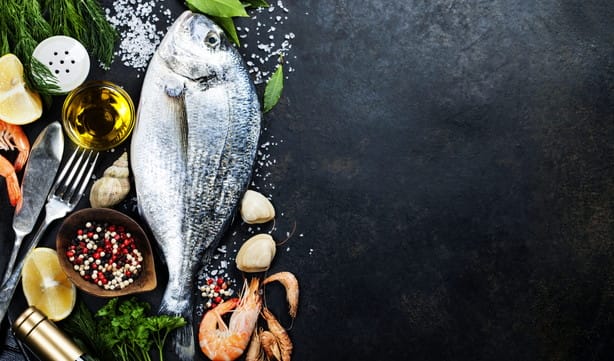 フランスの黒い背景に魚、野菜、ハーブ、スパイス。