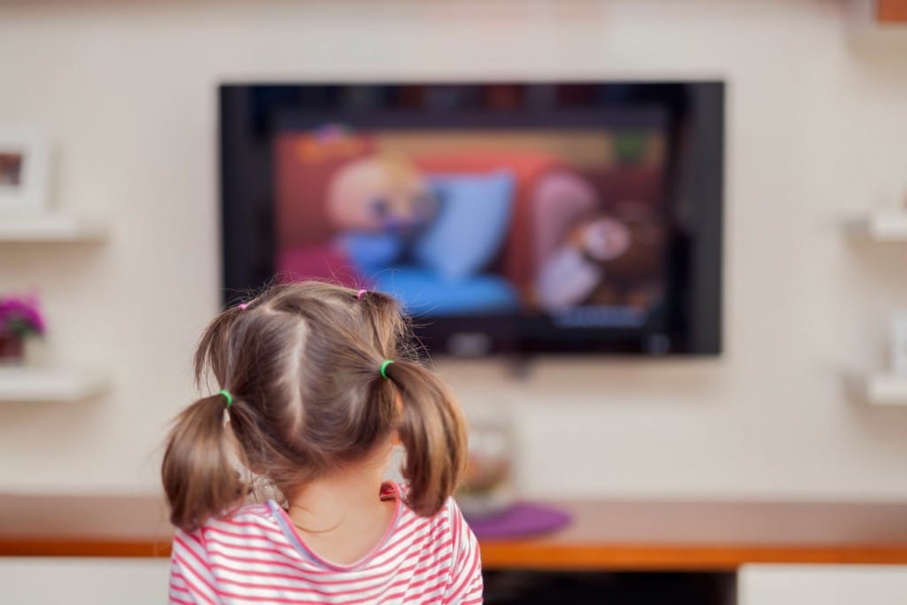 フランスのテレビの前でテレビを見ている小さな女の子。