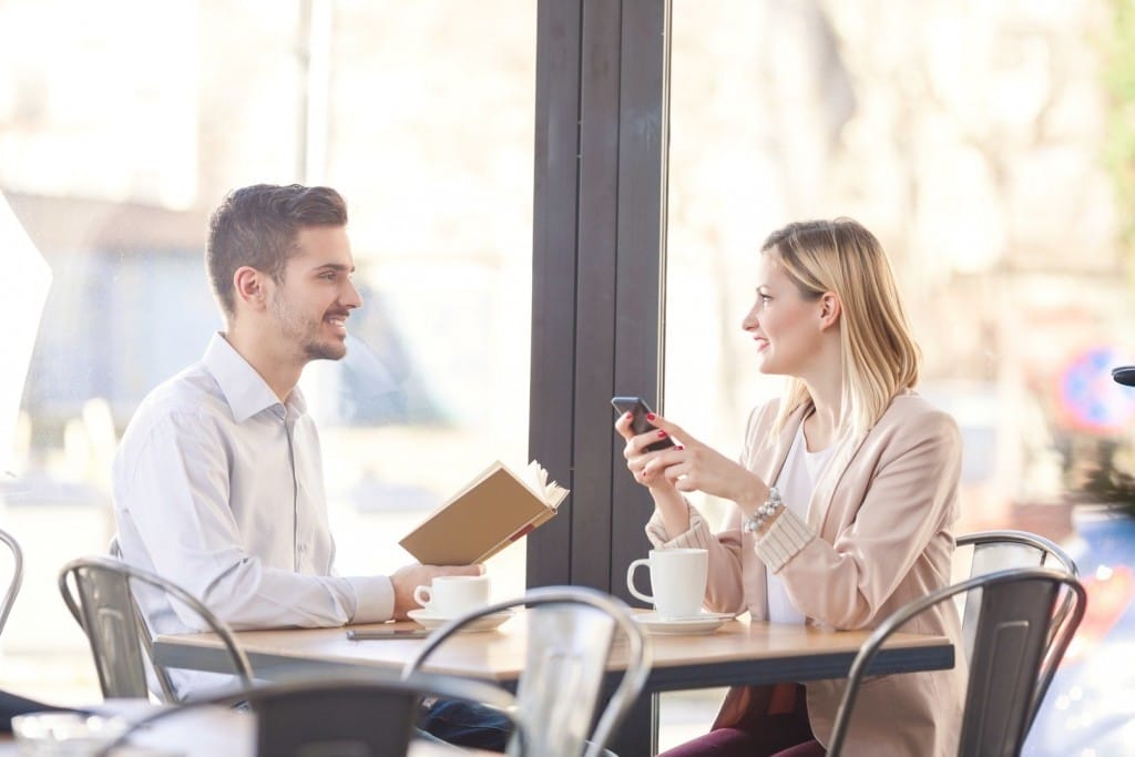 フランスのカフェのテーブルに男性と女性が座っています。