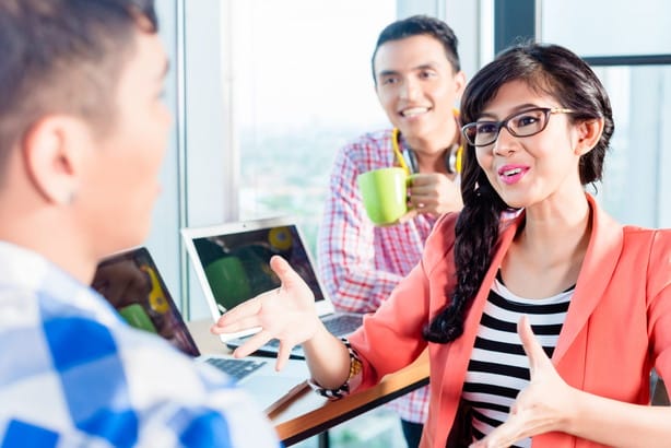 オフィスで互いに話している人々のグループ（フランスを含む）。