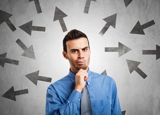 フランスで、さまざまな方向を指す矢印の前に男性が立っています。 フランスで、さまざまな方向を指す矢印の前に男性が立っています。