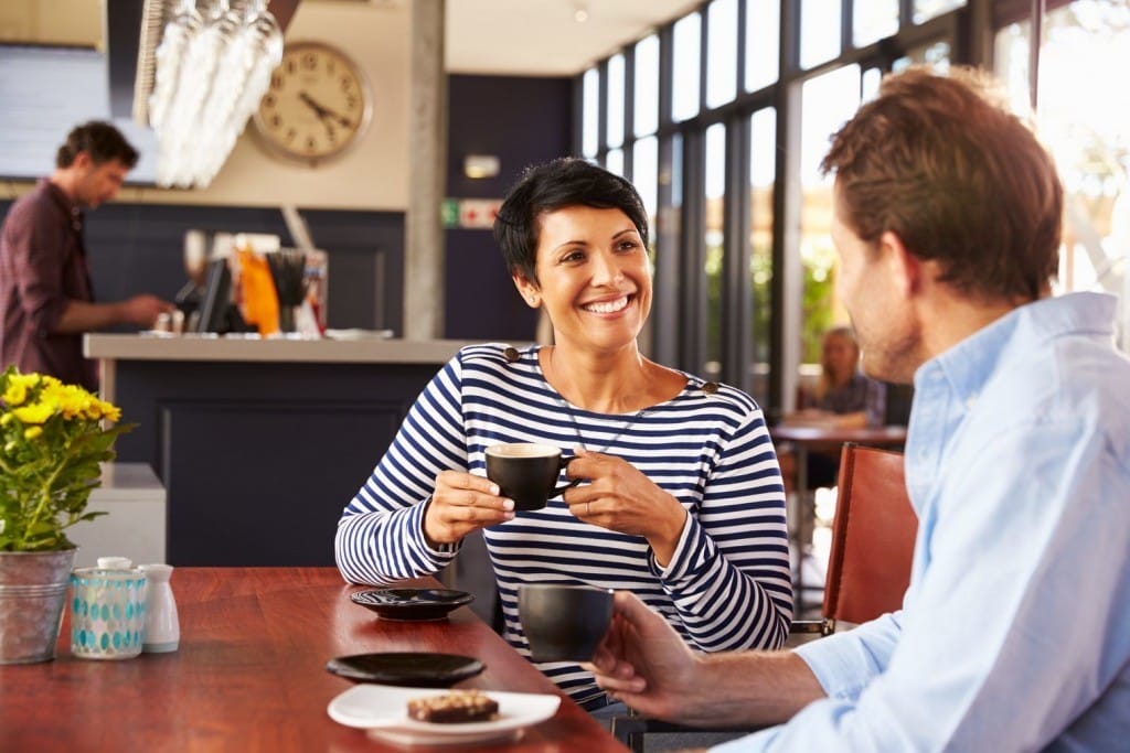 フランスのコーヒーショップのテーブルに座っている男性と女性。