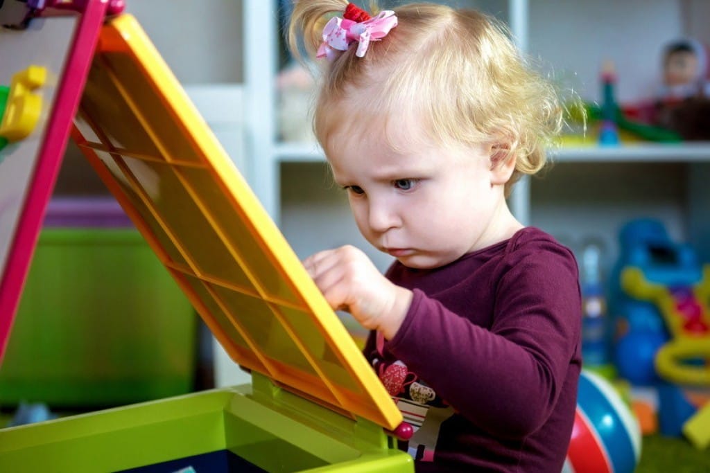 フランスから来た小さな女の子がおもちゃ箱で遊んでいます。