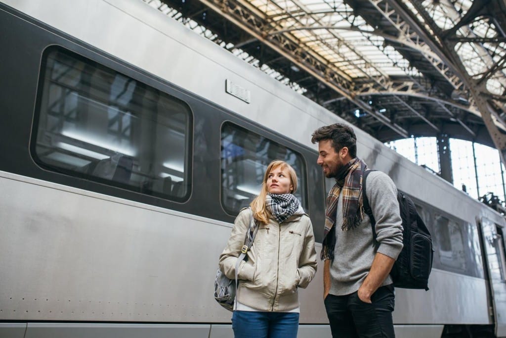 フランスの駅の前に立つ若いカップル。