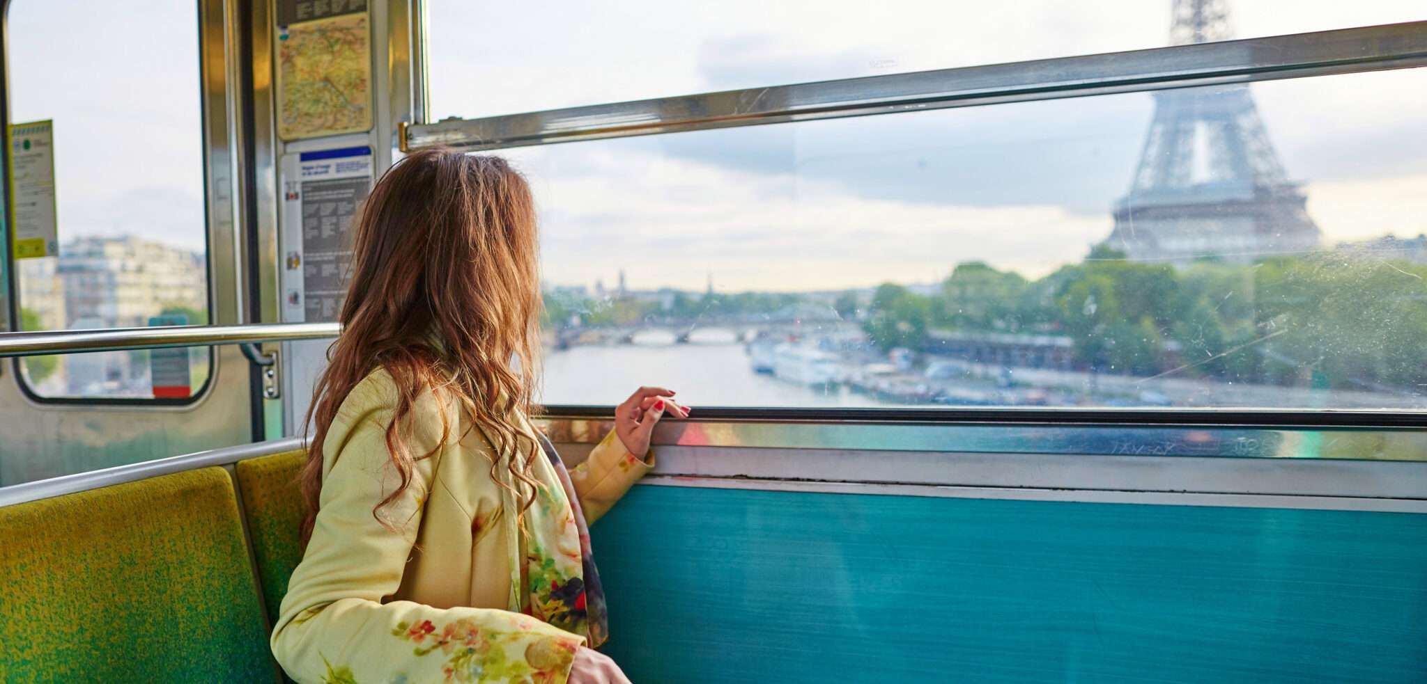 電車の窓からフランスのエッフェル塔を眺める女性。