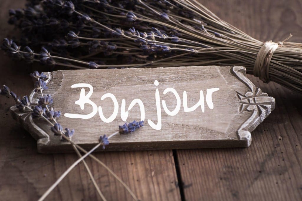 フランスのラベンダーの花の横に「bonjour」という言葉が書かれた木製の看板。