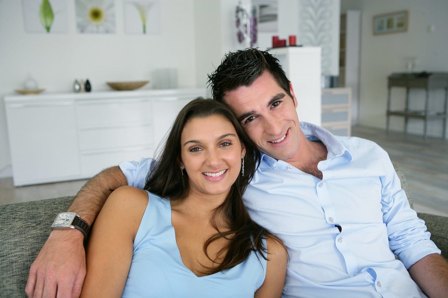 フランスのリビングルームのソファに座る若いカップル。