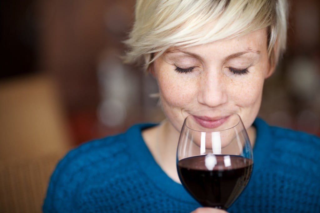 赤ワインをグラスで飲むフランスの女性。