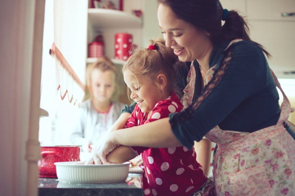 フランスのキッチンで食事を準備する女性と小さな女の子。