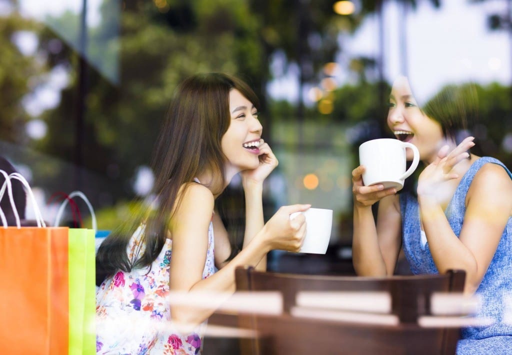 フランスのカフェでコーヒーを飲む 2 人のアジア人女性。