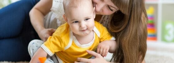 フランスの床でおもちゃで遊ぶ母親と赤ちゃん。