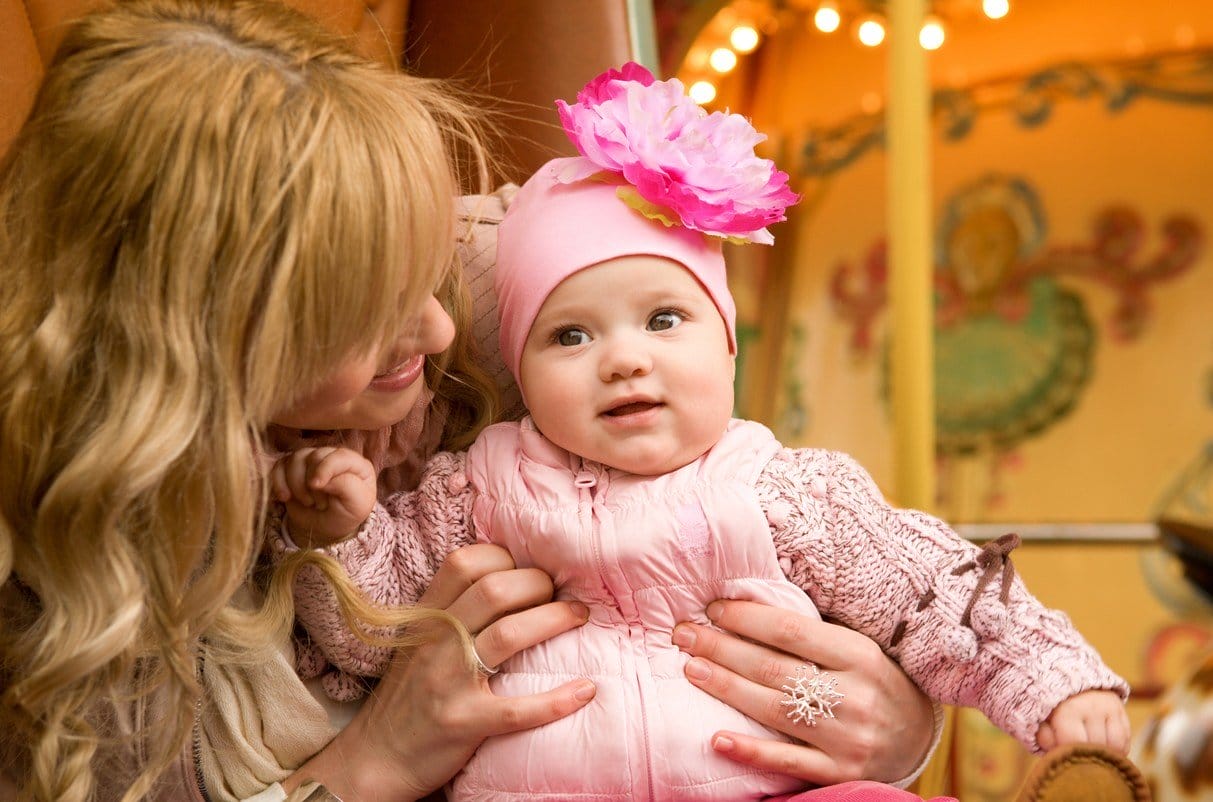 フランスのメリーゴーランドで赤ん坊を抱く女性。