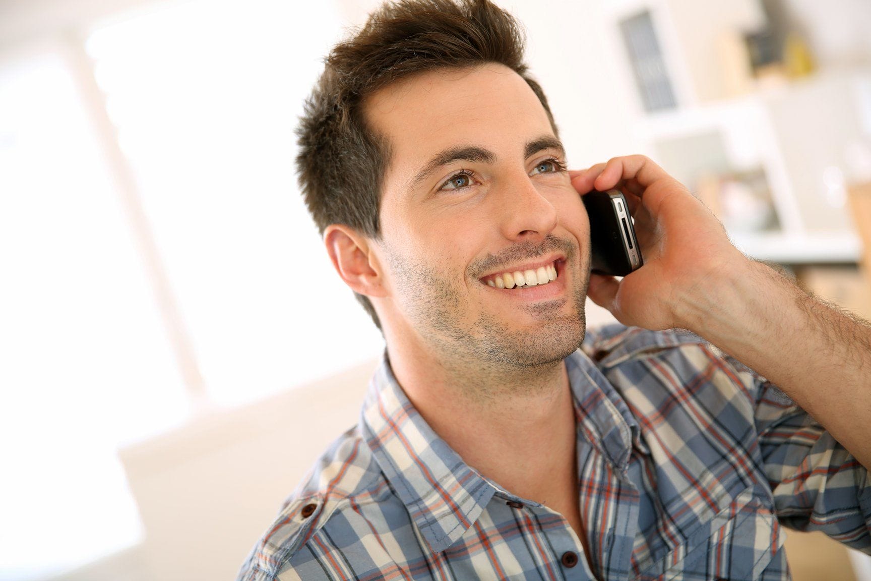 フランスで携帯電話で話しながら微笑む男性。 フランスで携帯電話で話しながら微笑む男性。